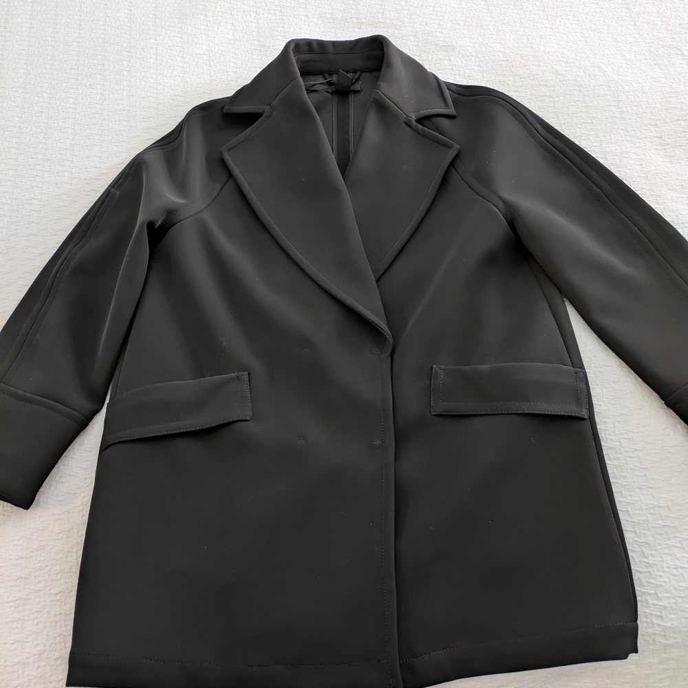 Black Trench Coat with Notched Lapel Collar and Structured Tailored Appearance